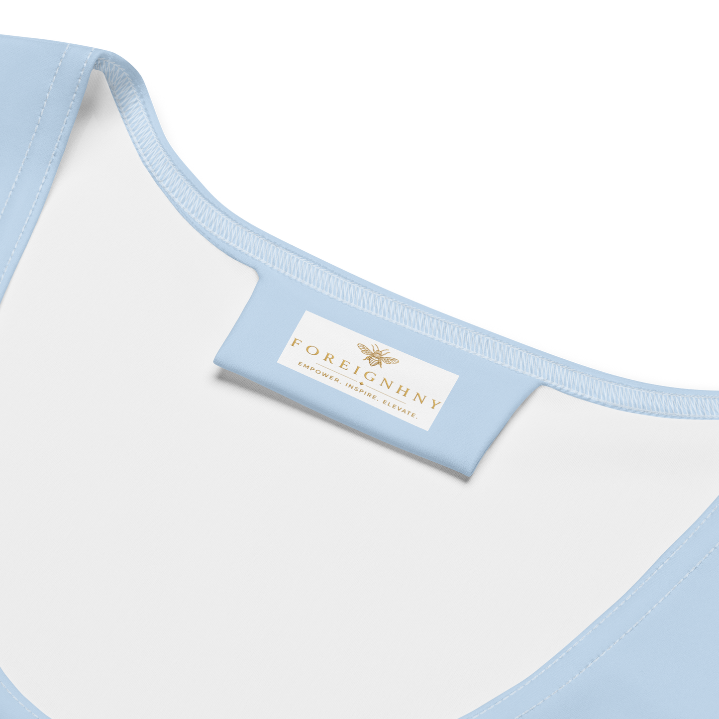 Close-up of a light blue and white garment with a visible brand label on a white background