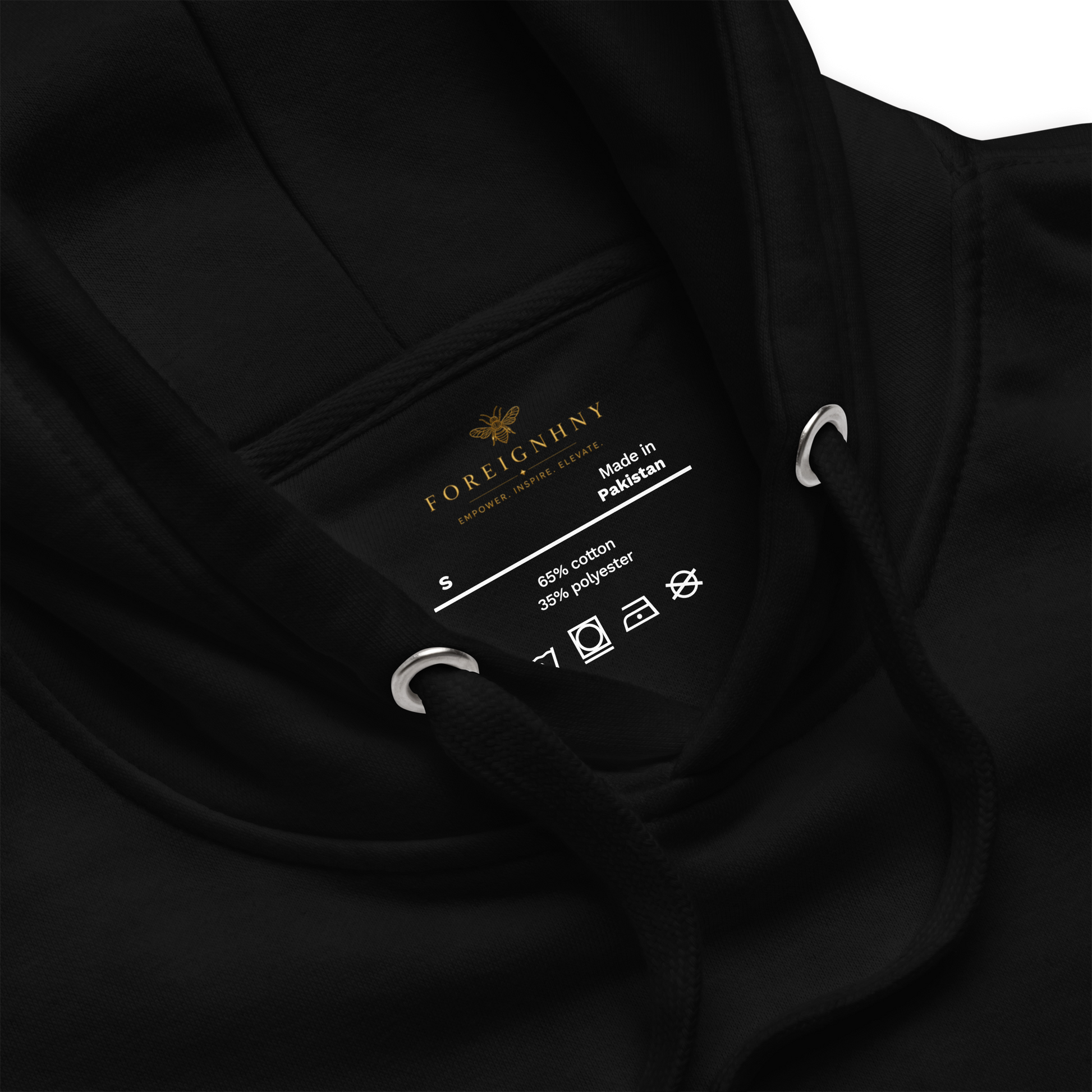 Close-up of a black garment label with brand name and details.